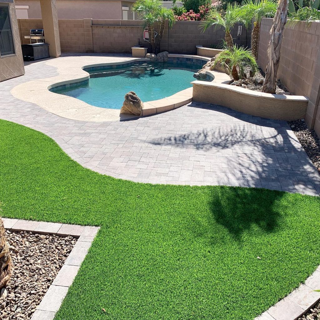 completely backyard transformation after photo showing perfectly installed pavers and artificial turf