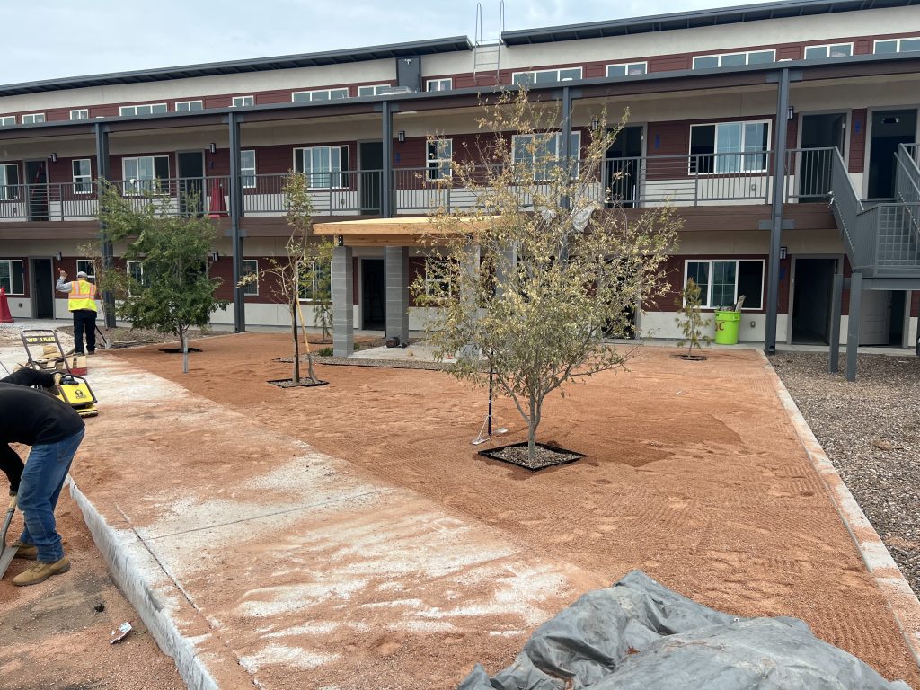 front of a commercial apartment complex being renovated with landscape and hardscape 