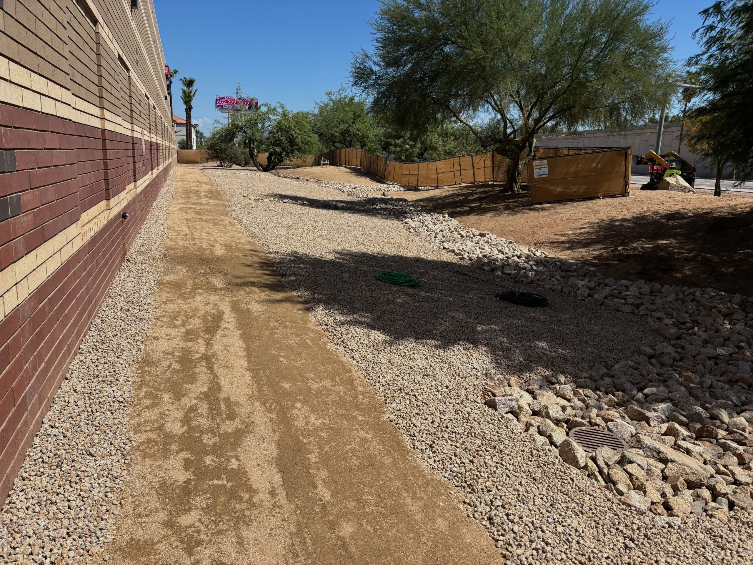 after view of a gravel and river rock covered easement allowing for draining and a delineated walking path